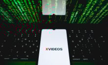 The XVideos logo is being displayed on a smartphone screen