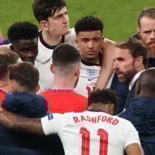 Gareth Southgate, head coach of England, talking to his players during a football game.