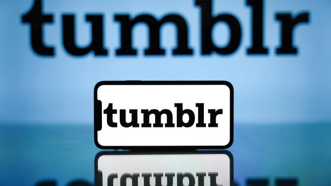 Tumblr logo displayed on a mobile phone screen and in the background.